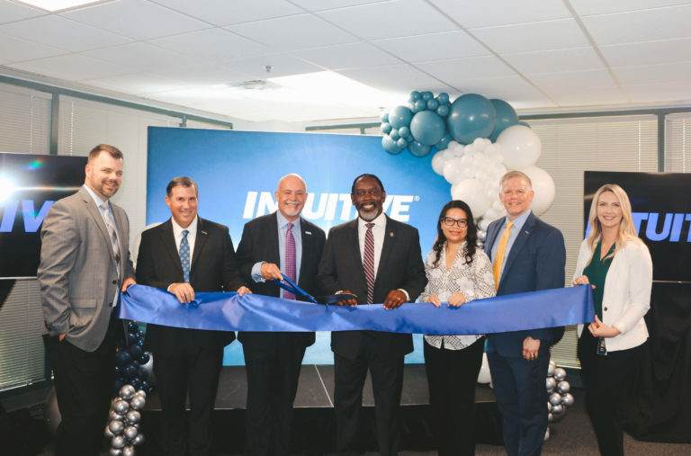 Co-Founder and Chairman Harold Brewer and fellow INTUITIVE employees holding a blue ribbon and scissors at our new Orlando office location.